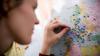 Woman putting pins in a map of the world