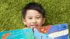 Boy with a children's book laying on the grass